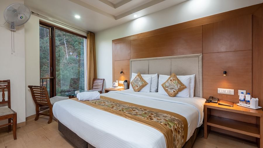 A bedroom featuring a king size bed and a table with tea & coffee make next to the bed at DLS Hotels The Rock Castle.